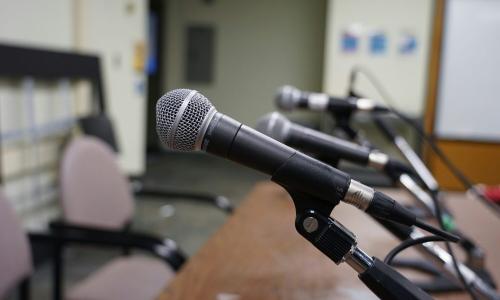 Line of microphones at a table